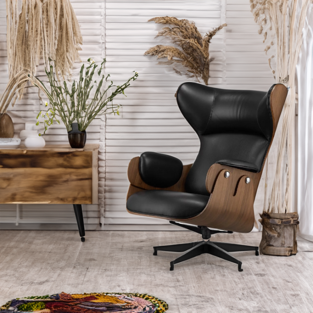 Wnętrze w stylu boho - inspiracja. Duży fotel wypoczynkowy uszak widnieje na tle białej ściany oraz posadzki z jasnego drewna. Obok fotela znajduje się niska drewniana komoda oraz kolorowy dywan z frędzlami. 
